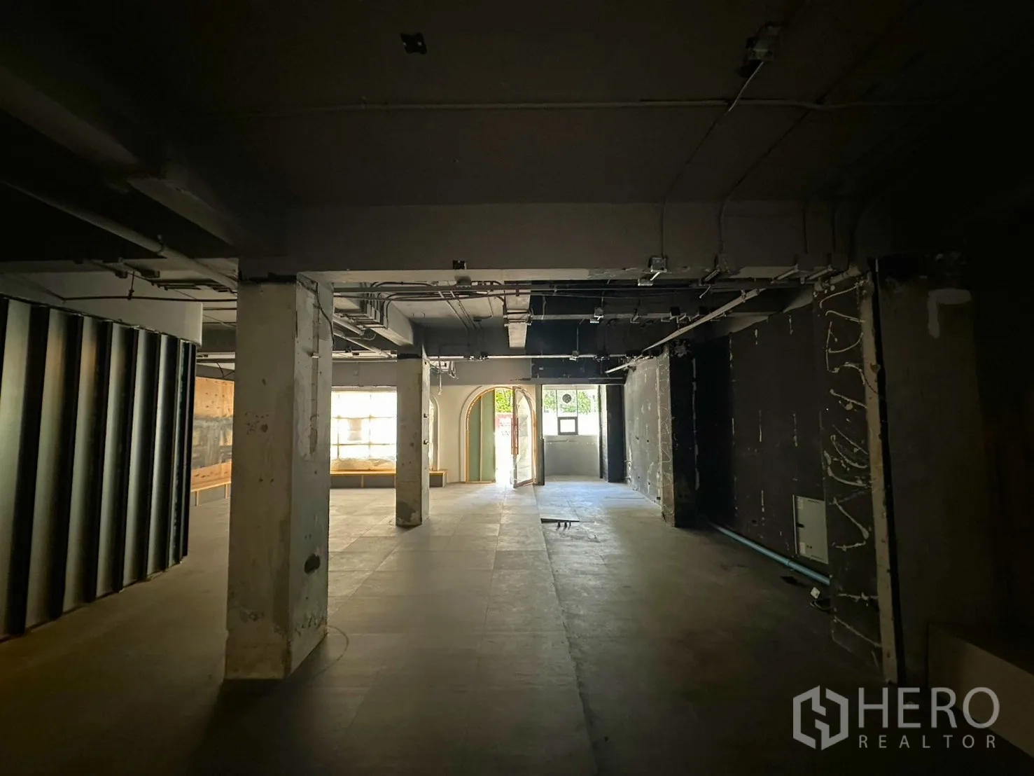 พื้นที่ขายของ for rent in Watthana, Bangkok - มองจากด้านในไปทางทางเข้า เห็นเสา เพดานโชว์งานระบบ และประตูกระจก.