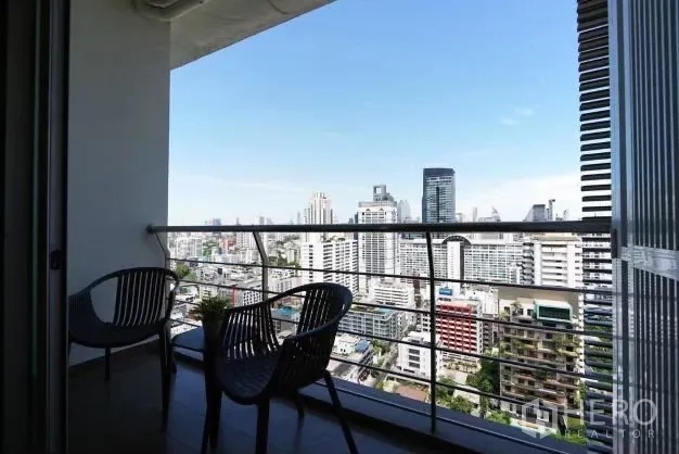 公寓 出租在Watthana, Bangkok - 带顶阳台，摆放两把椅子，远眺曼谷天际线与城市景观。