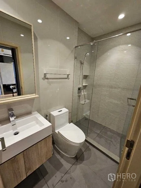 Condominium for rent - Second bathroom with walk-in glass shower, vanity and modern toilet.
