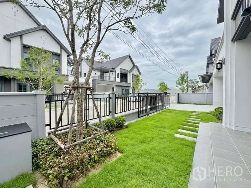 独立式住宅 出售在Bang Phli, Samut Prakan - 前庭草坪与黑色金属大门