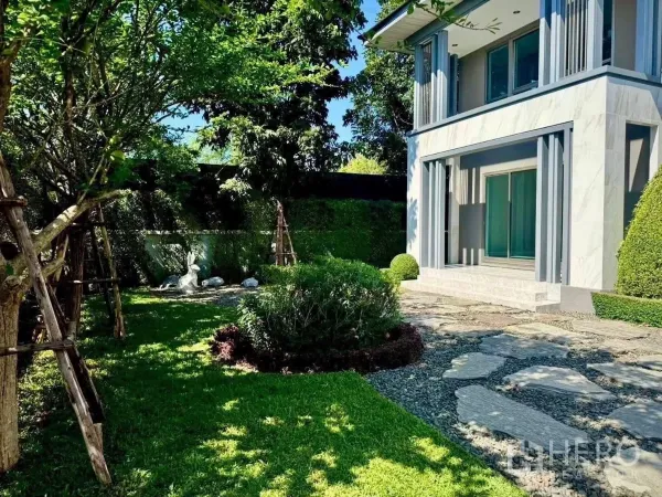 Detached House for rent in Lat Krabang, Bangkok - Landscaped side garden with mature trees, hedges and a stone path beside the house.