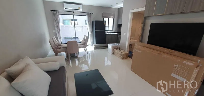 带办公室的家 出租在Prawet, Bangkok - 通透明亮的客餐厅与开放式厨房，瓷砖地面和大窗户。