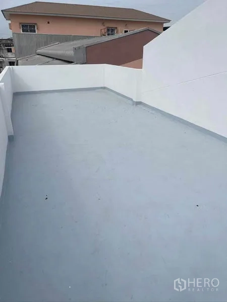 Warehouse for rent in Mueang Samut Sakhon, Samut Sakhon - Open rooftop terrace with waterproof floor and parapet walls overlooking neighboring buildings.