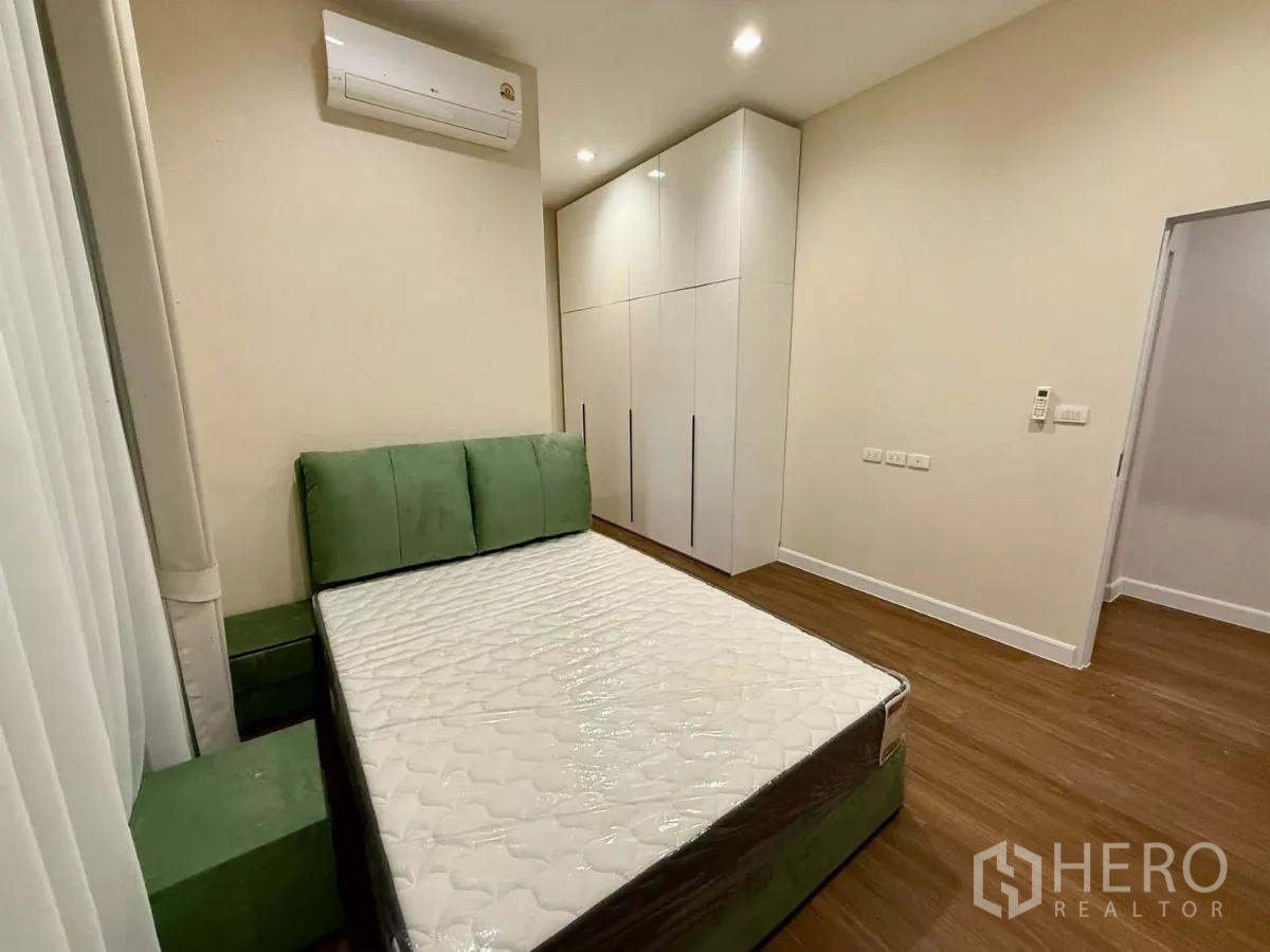 独立式住宅 出租在Bang Phli, Samut Prakan - 第三卧室，绿色床头、衣柜与木地板。
