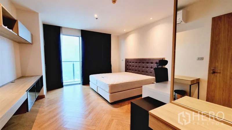 คอนโด ขายในWatthana, Bangkok - ห้องนอนมีประตูออกระเบียง เห็นวิวเมือง พร้อมโต๊ะทำงานบิลท์อินและหัวเตียงบุผ้า