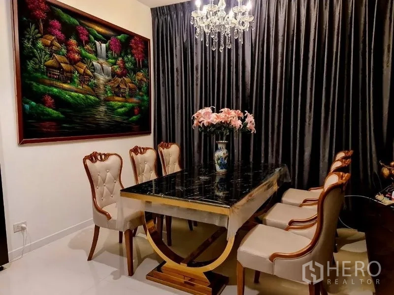 Detached House for rent or sale in Pathum Thani - Elegant dining corner with six-seat marble-top table, crystal chandelier and framed artwork.