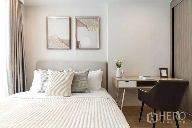 Condominium for rent - Primary bedroom with desk, artwork and padded headboard.