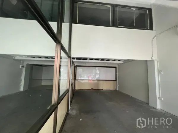 店屋 出租在Khlong Toei, Bangkok - 一层宽敞门店区域，夹层窗与后部玻璃隔间清晰可见。