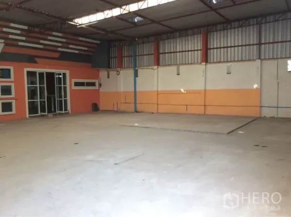 货栈 出租在Nong Chok, Bangkok - 曼谷Nong Chok仓库内部，高挑钢结构屋顶、混凝土地面与玻璃门办公室。