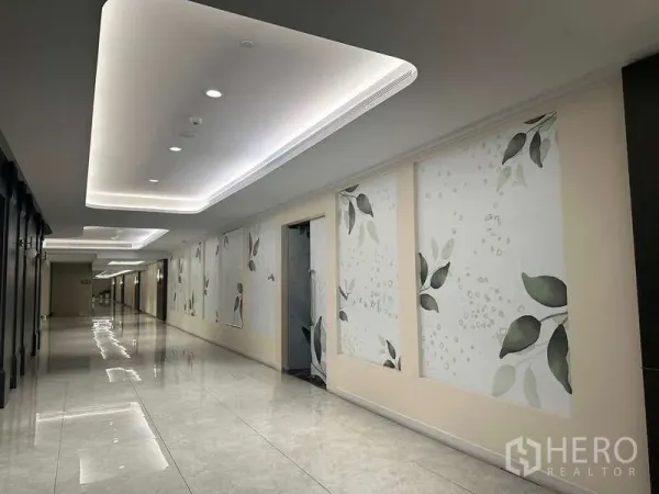 Retail Space for rent - Renovated mall corridor with cove lighting, glossy flooring and leaf-pattern wall panels.