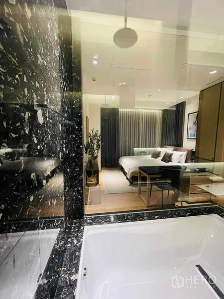 Condominium for rent in Khlong Toei, Bangkok - View from the bathtub through the glass wall to the bedroom with soft curtains.