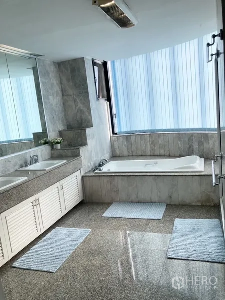 Condominium for rent in Yan Nawa, Bangkok - Primary bathroom with double vanity, bathtub and marble finishes.