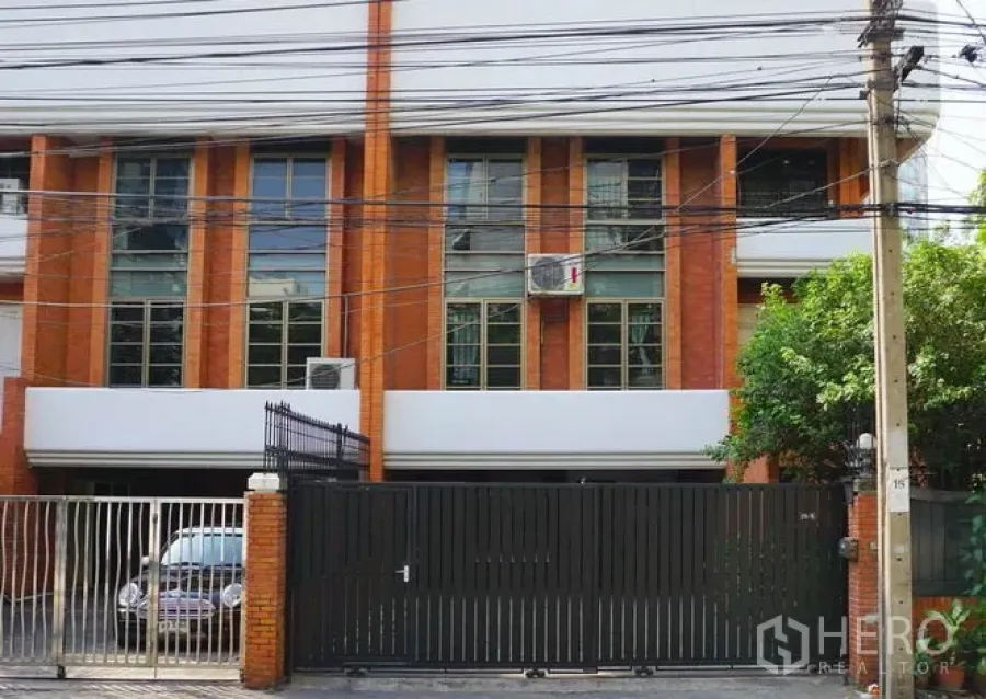 ทาวน์เฮาส์ ให้เช่าในPathum Wan, Bangkok - หน้าบ้านทาวน์เฮ้าส์อิฐพร้อมประตูรั้วและหน้าต่างสูง