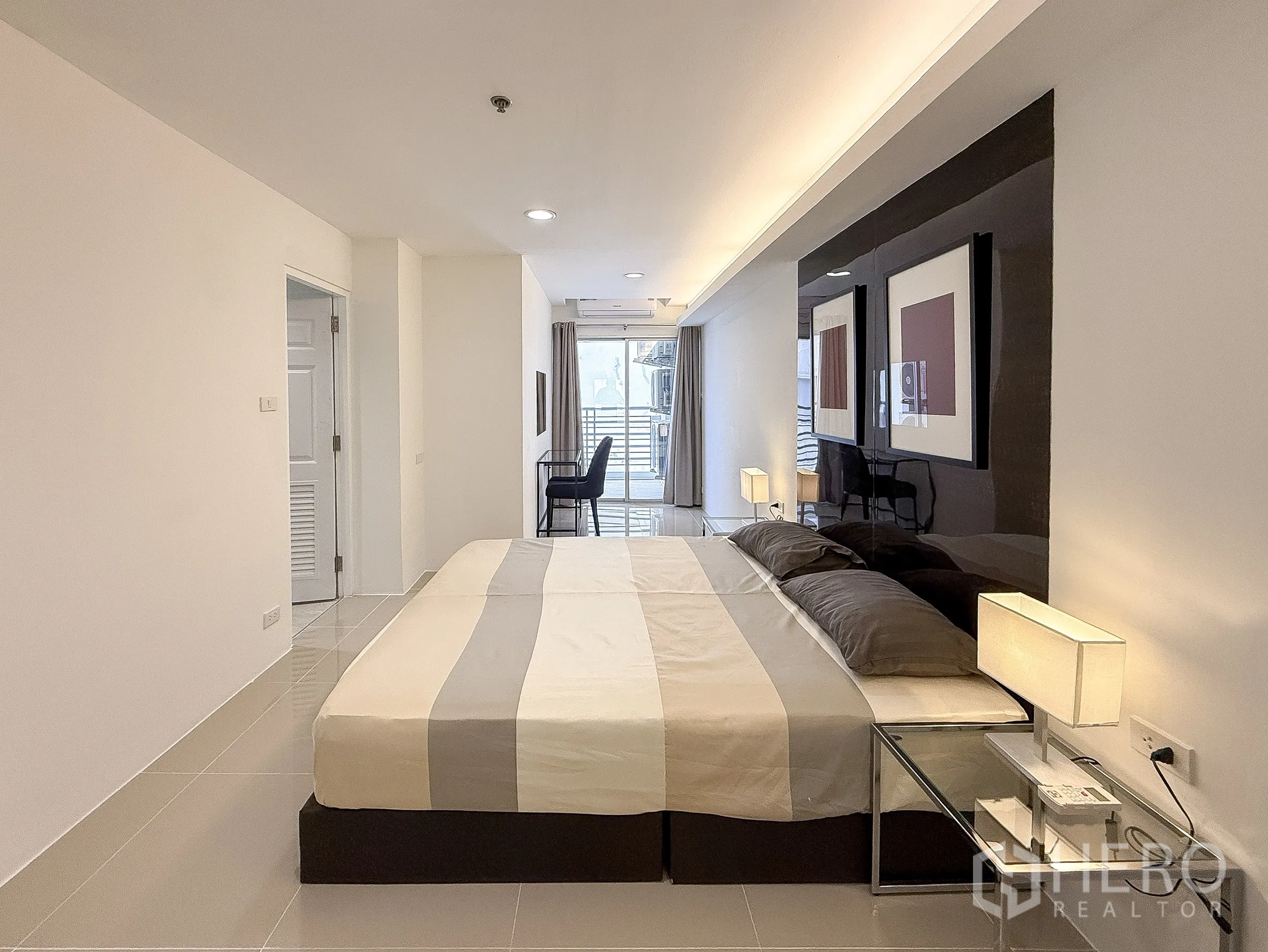 公寓 出租在Khlong Toei, Bangkok - 细长型卧室布局，床头灯并通向阳台与书写区。