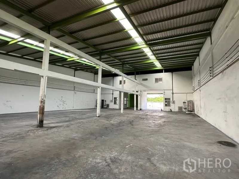 货栈 出租在Pathum Thani - 仓库内部空间开阔，钢结构高挑屋顶与天窗，耐用混凝土地面。
