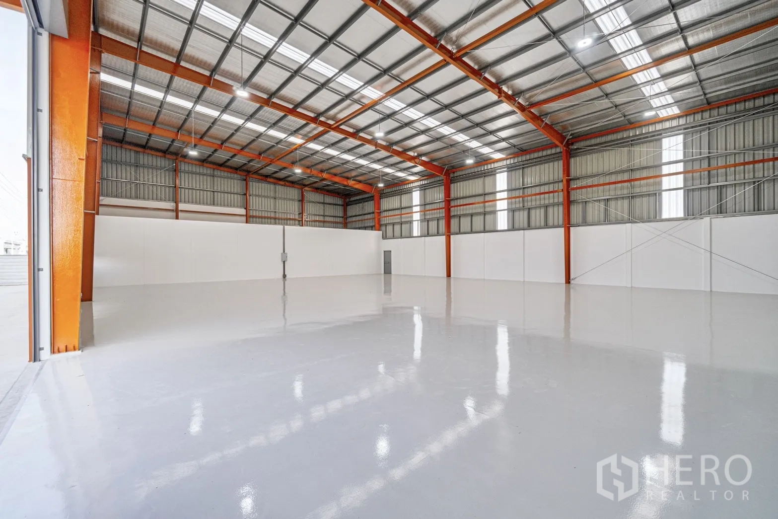工厂 for rent or sale in Lam Luk Ka, Pathum Thani - 仓库内部高挑钢结构屋顶、橙色立柱与光亮地面。