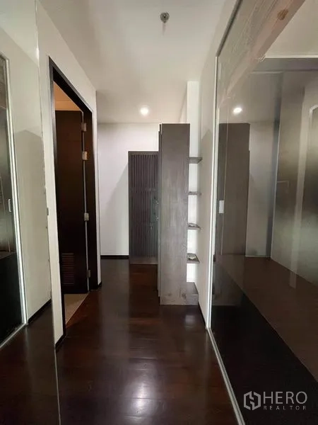 公寓 出租或出售在Watthana, Bangkok - 走廊两侧为镜面衣柜，深色木地板
