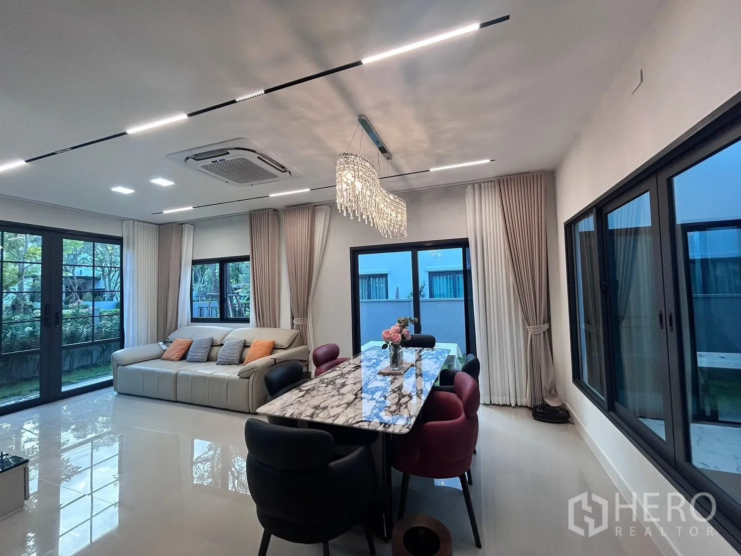 บ้านแฝด for rent in Bang Phli, Samut Prakan - พื้นที่นั่งเล่นและรับประทานอาหารแบบเปิด มีโต๊ะหินอ่อน โคมไฟ และวิวสวน