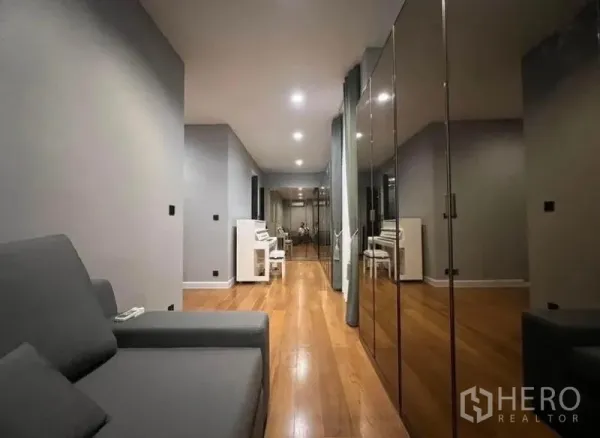 Detached House for rent - Long hallway lounge with wooden floors, mirrored wardrobes and a piano in a modern Bangkok detached house.