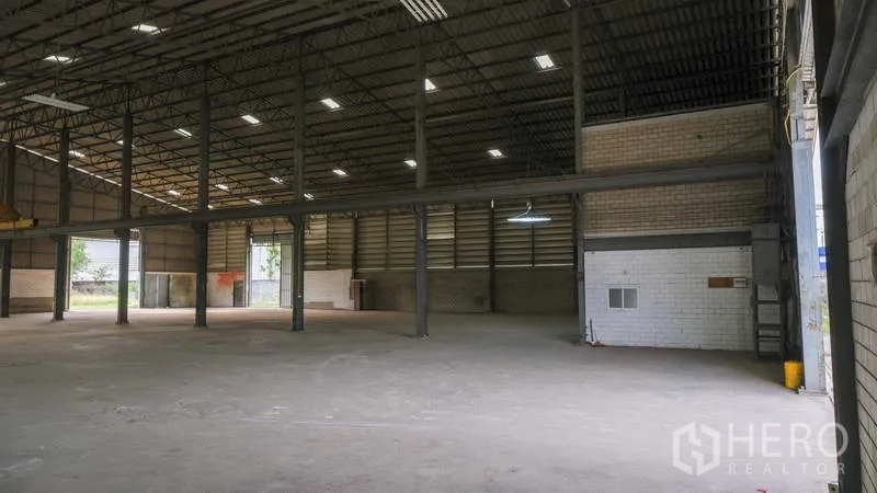 Factory for rent in Bang Phli, Samut Prakan - Open production floor with steel columns, skylights and brick side walls.