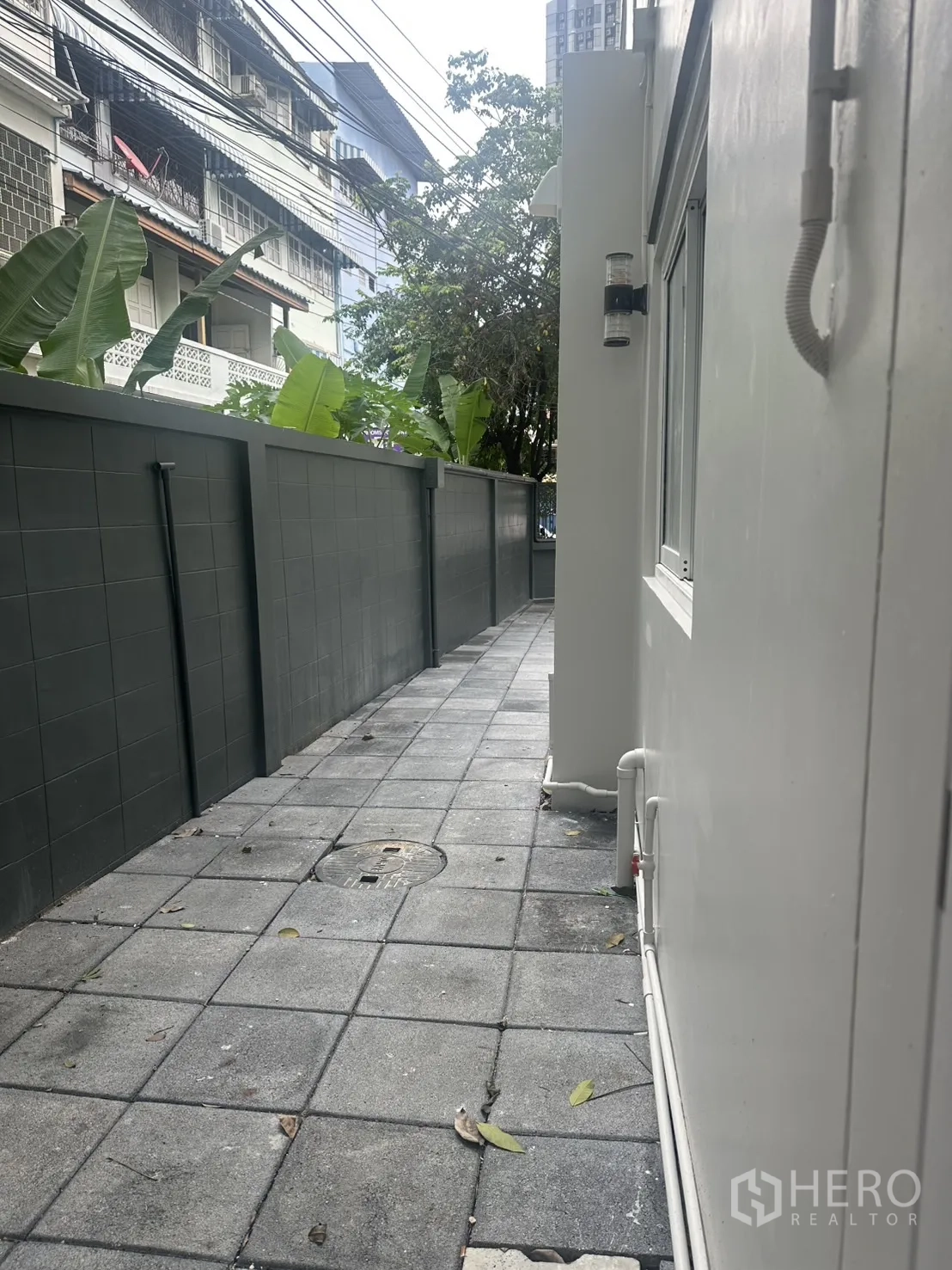 带办公室的家 出租在Khlong Toei, Bangkok - 沿高墙的侧边通道，上方有城市电线。