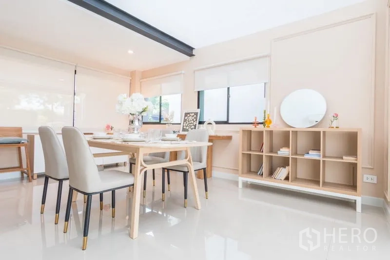 Townhouse for rent or sale in Suan Luang, Bangkok - Wide view of the dining area with built-in shelving and large windows.