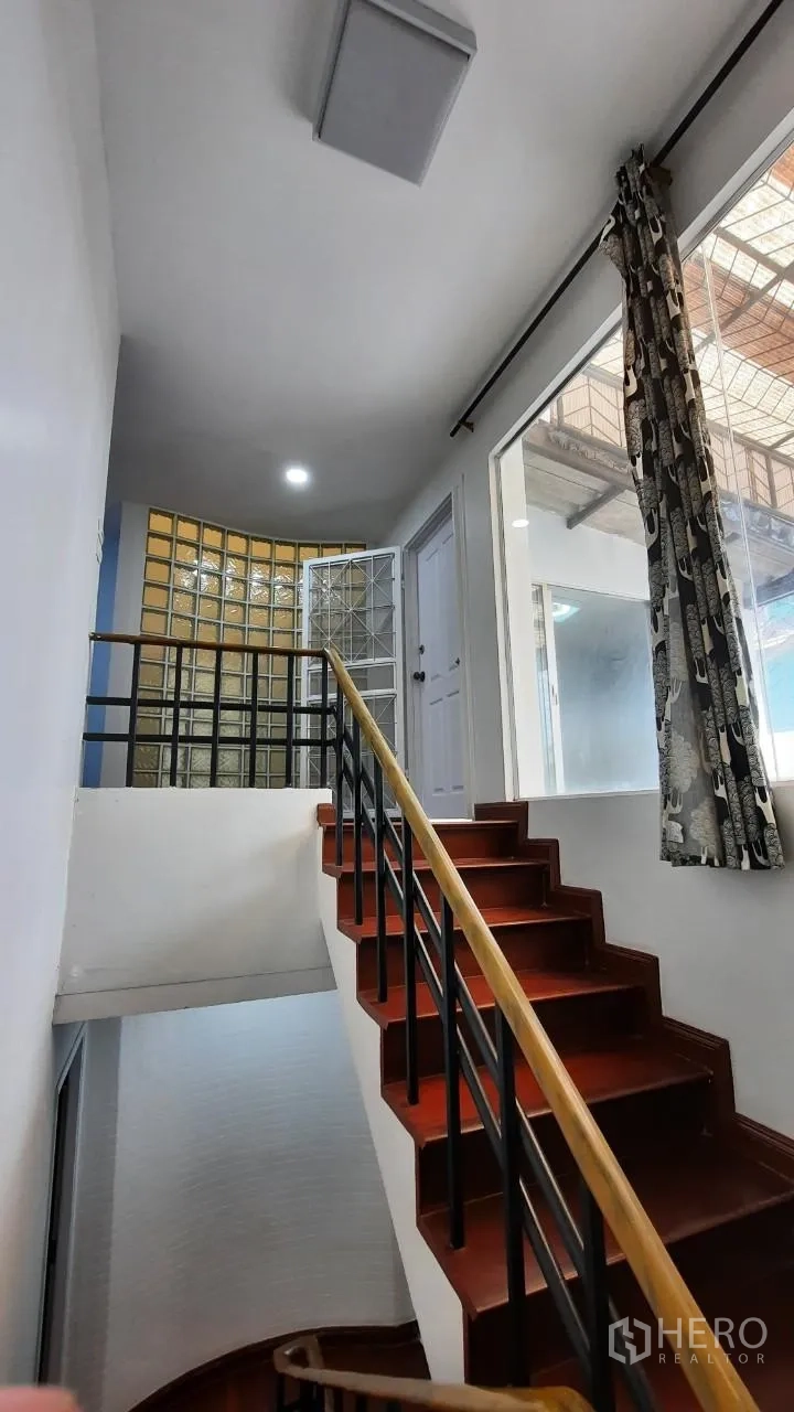 Townhouse for sale in Suan Luang, Bangkok - Stairway landing with curved glass-block wall and natural light