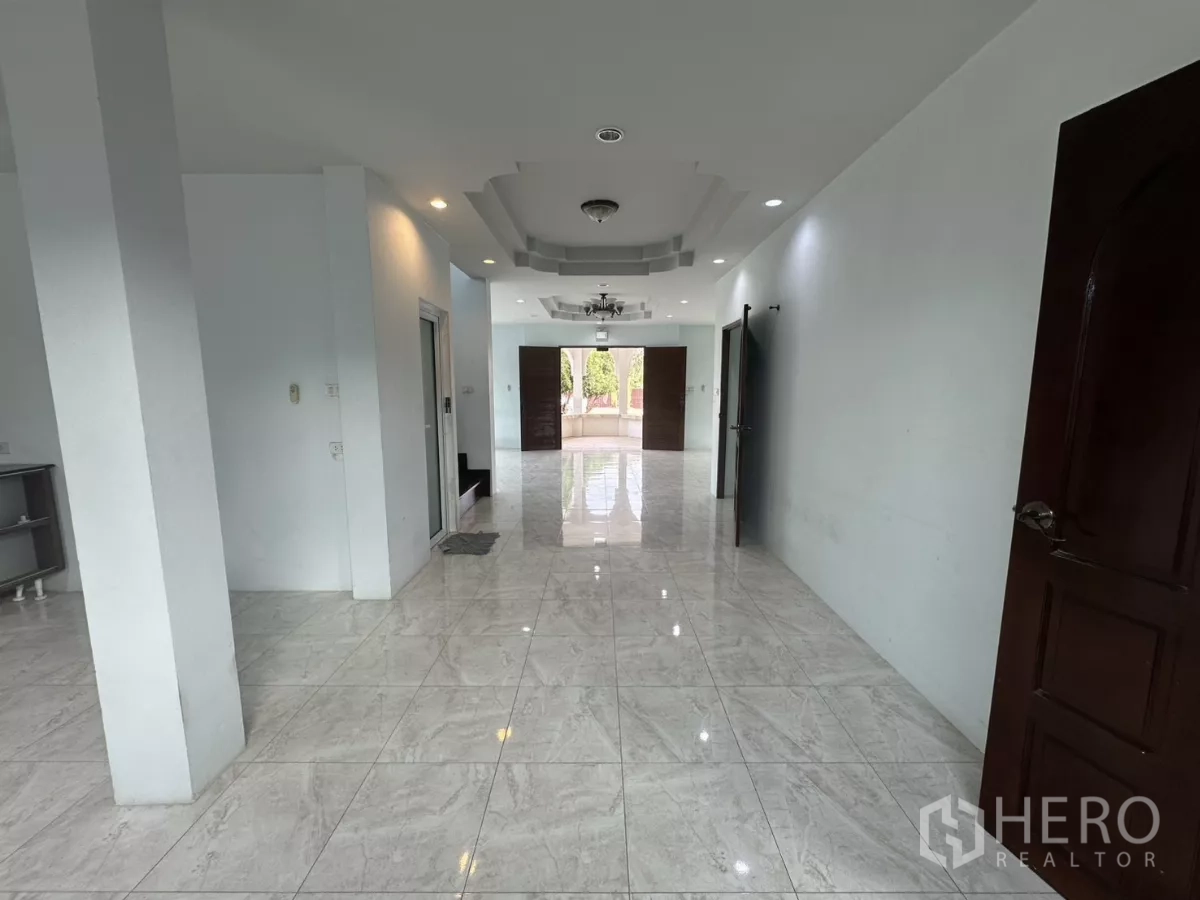 Home Office for rent - Interior corridor with columns, recessed lighting and white tiled floors.