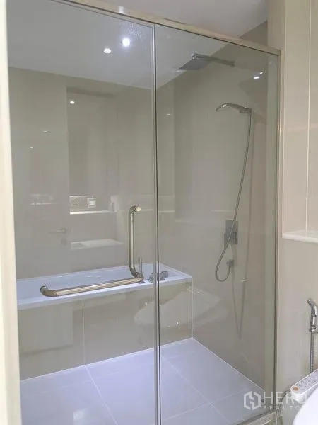 Condominium for rent in Watthana, Bangkok - Glass-enclosed shower and bathtub combination with handheld shower set.