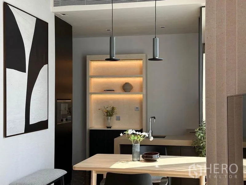 Condominium for rent in Pathum Wan, Bangkok - Sleek kitchenette with mirrored upper cabinets, stone countertop and stainless faucet.