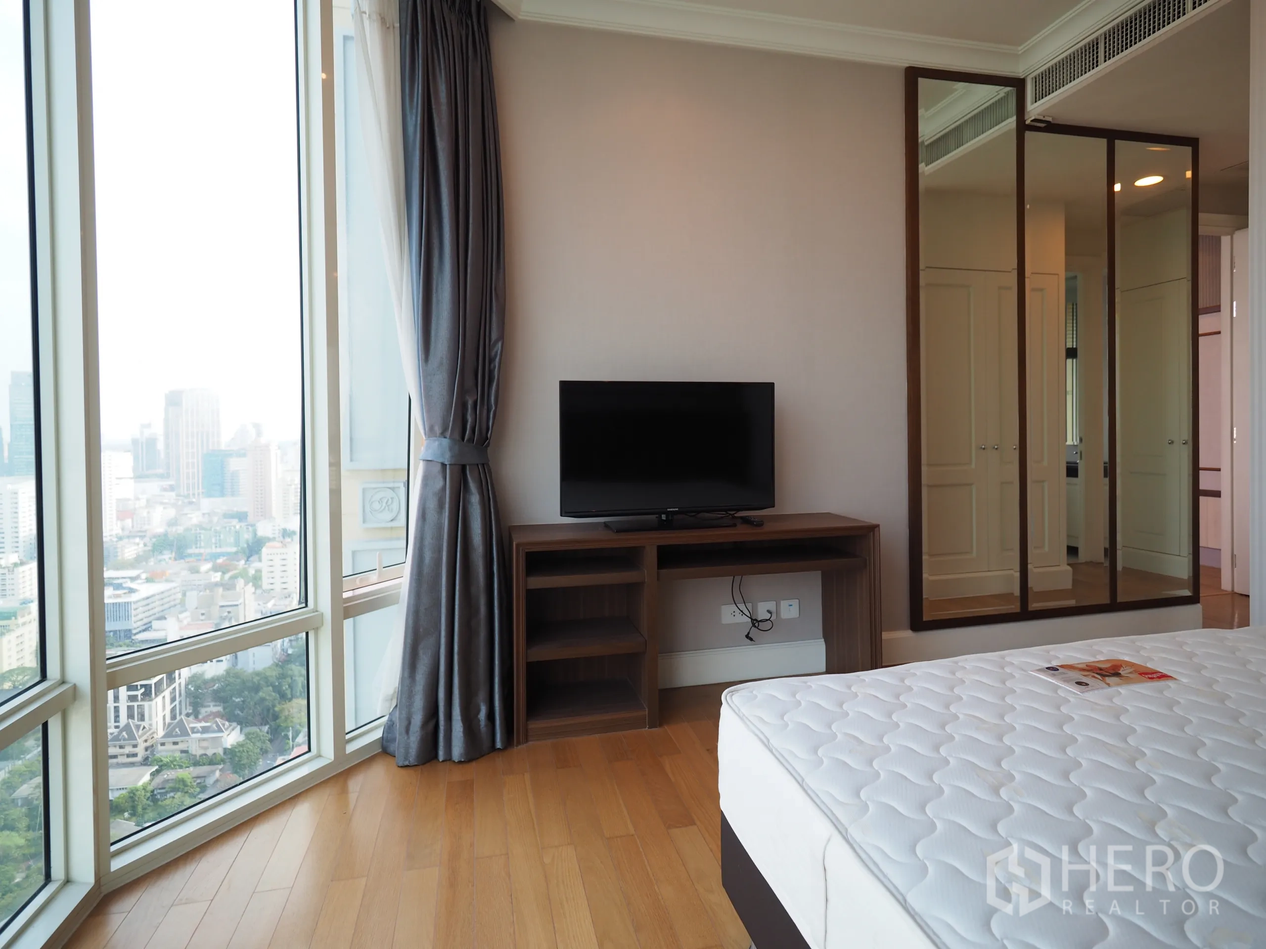 公寓 出租在Watthana, Bangkok - 卧室配落地窗、电视柜与镜面衣柜。