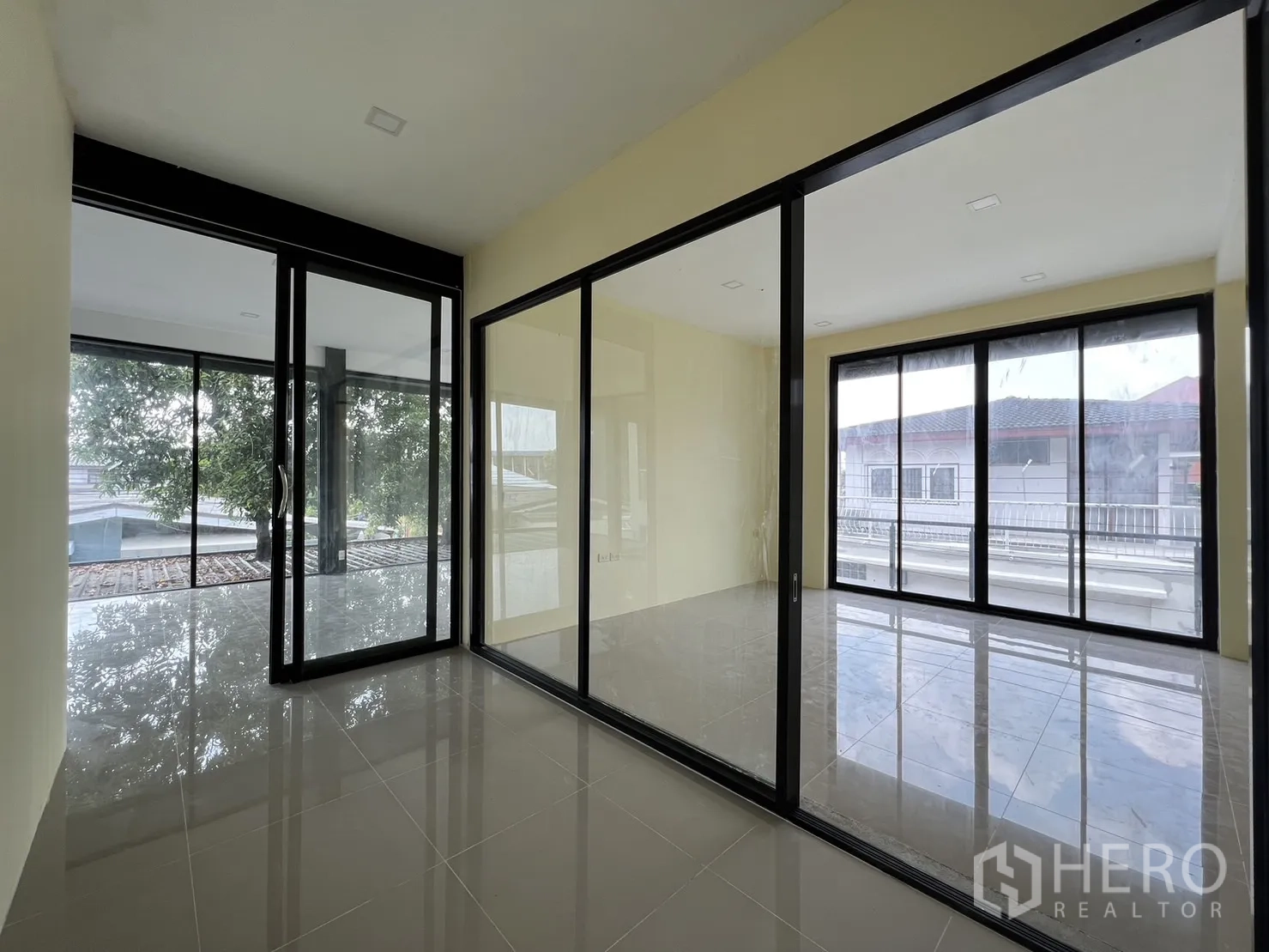 Detached House for rent or sale in Phra Khanong, Bangkok - Corner suite with multiple glass partitions connecting bright rooms.