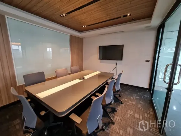 Office Space for rent in Bang Rak, Bangkok - Private meeting room with TV display, frosted glass panels, and wood-accent ceiling.