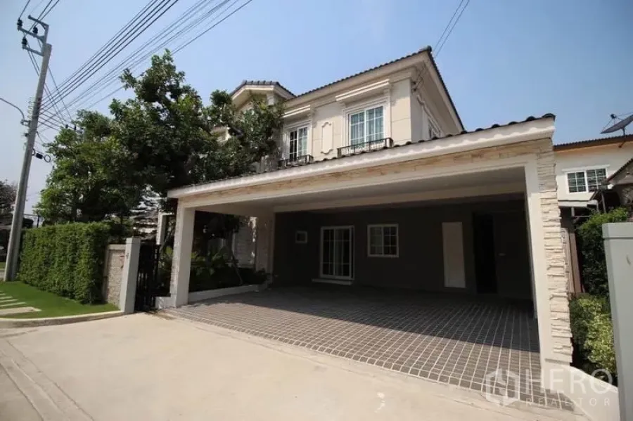 独立式住宅 出租或出售在Lat Phrao, Bangkok - 两层独栋别墅，带双车位车棚与绿篱围合的静街外观。