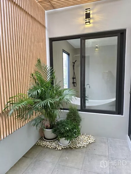 独立式住宅 出售在Khlong Toei, Bangkok - 浴室旁小庭院，摆放绿植与木质格栅。