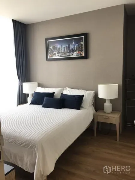公寓 出租在Khlong Toei, Bangkok - 主卧配白色床品、床头灯与大窗帘窗，采光充足。