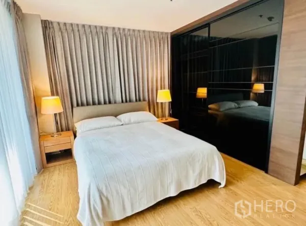 คอนโด ให้เช่าในWatthana, Bangkok - ห้องนอนหลัก เตียงควีน โคมไฟหัวเตียง และตู้เสื้อผ้าบานกระจก