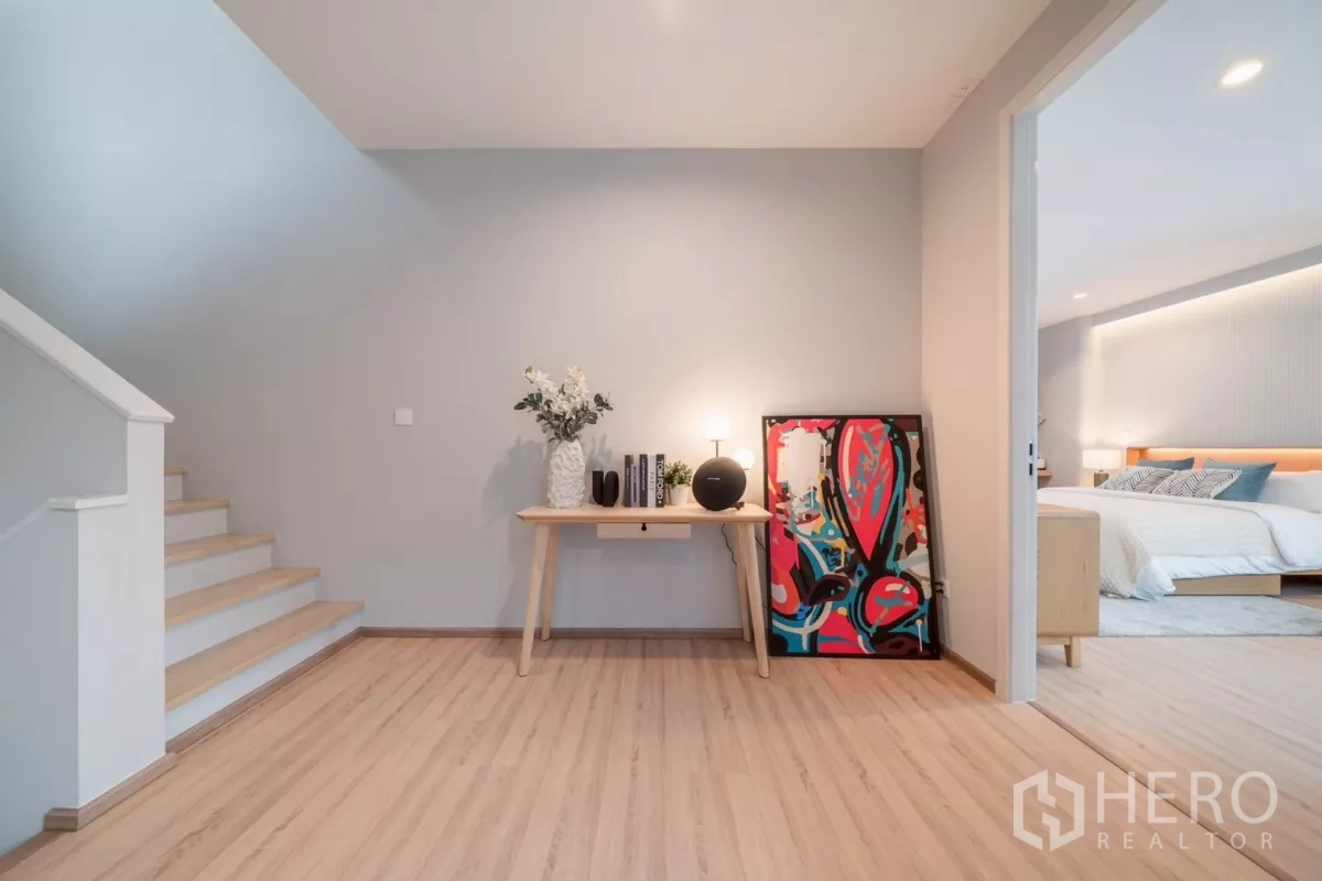 Detached House for rent in Saphan Sung, Bangkok - Landing with console table, wood floors and doorway leading to a bedroom.