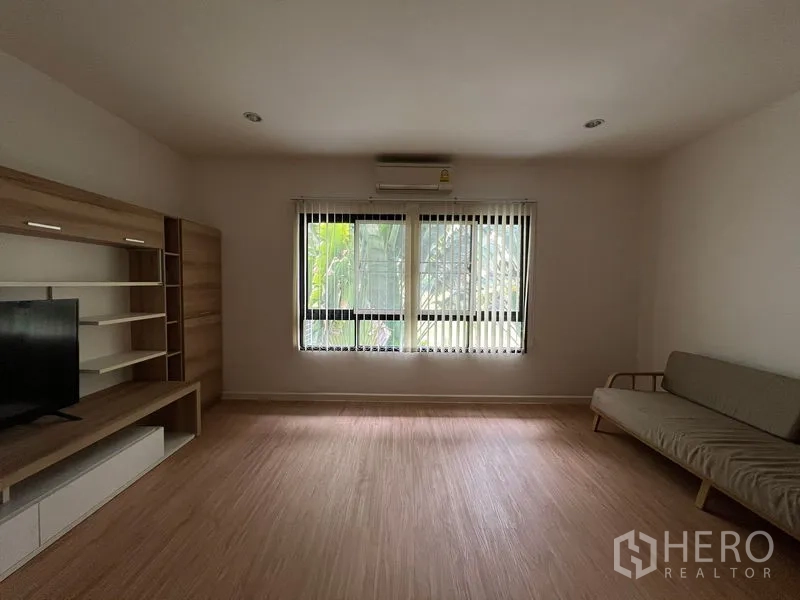 Townhouse for rent in Bang Kapi, Bangkok - Living room with TV cabinet, sofa and wide window with blinds.