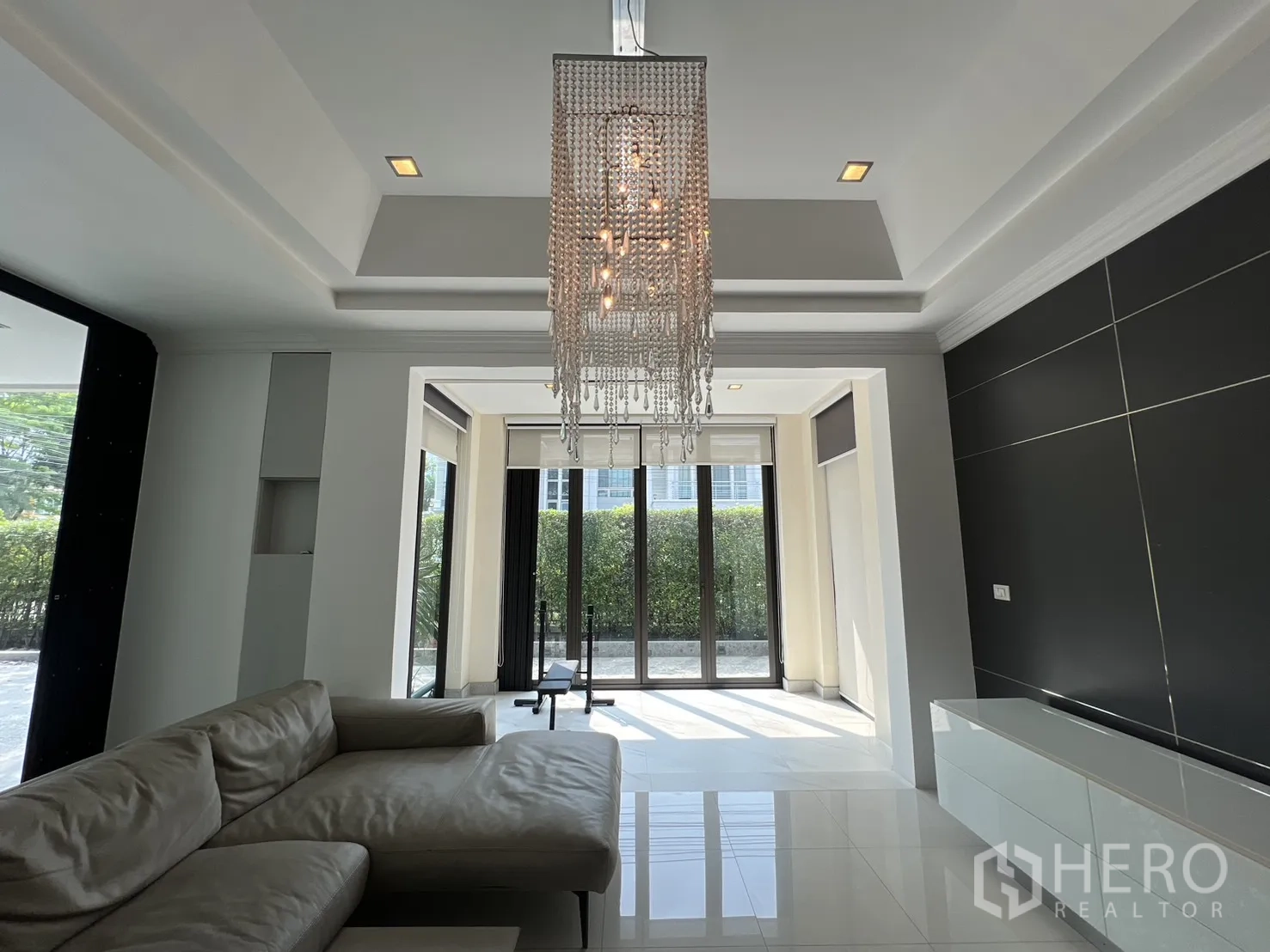 Detached House for rent in Prawet, Bangkok - Close view of a crystal chandelier in a modern living area with floor‑to‑ceiling windows.