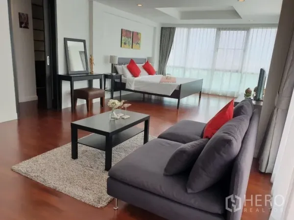 公寓 出租在Bang Rak, Bangkok - 超大主卧套间，设休闲沙发区、茶几与床，环幕式窗户。