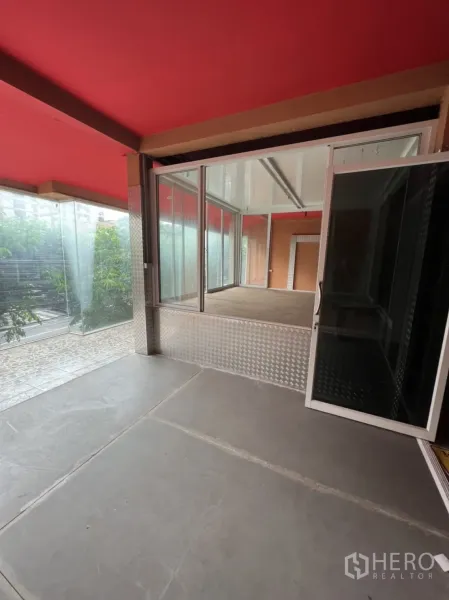 Shophouse for rent in Watthana, Bangkok - Upper-level open space with sliding glass doors and corner windows overlooking the street.