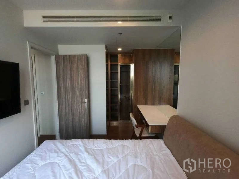 公寓 出租在Khlong Toei, Bangkok - 主卧配床、书桌与木质步入式衣帽间。