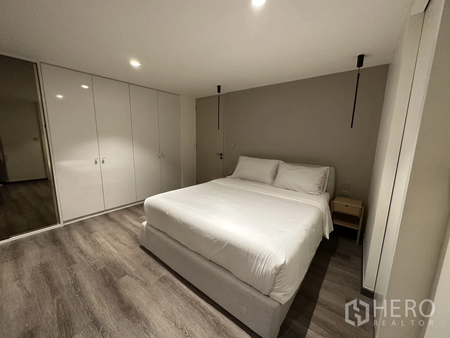 Condominium for rent or sale in Watthana, Bangkok - Bedroom with double bed, pendant lights, and full-height wardrobes.