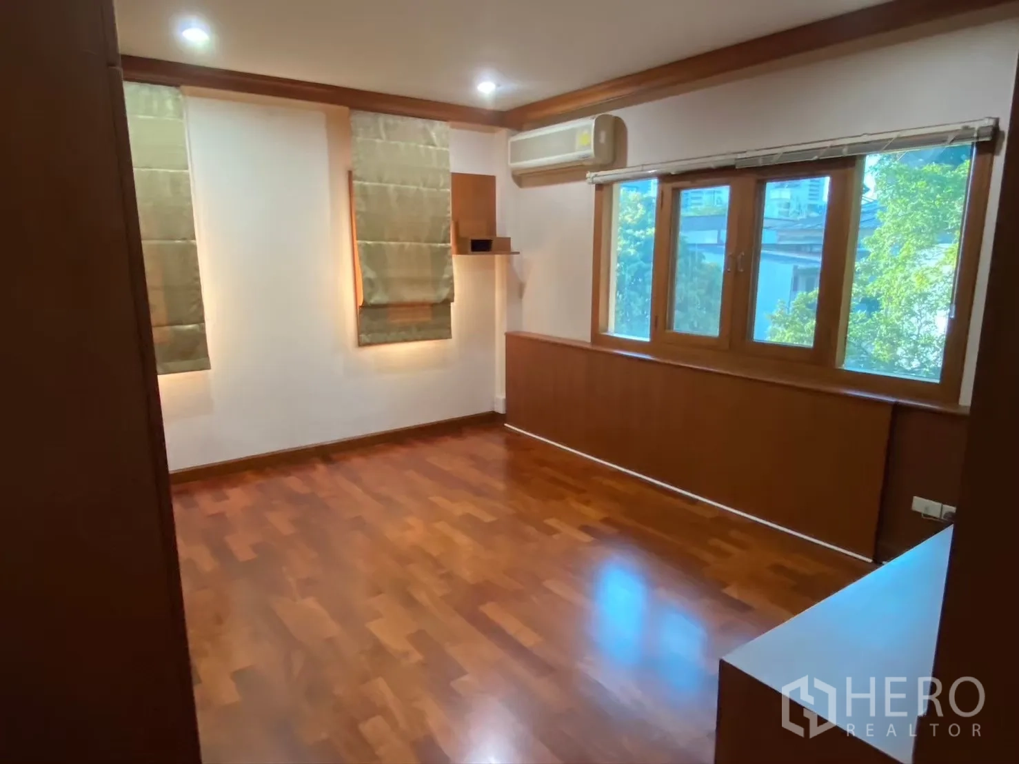 Detached House for rent in Watthana, Bangkok - Bright bedroom with large window, AC and wood flooring.