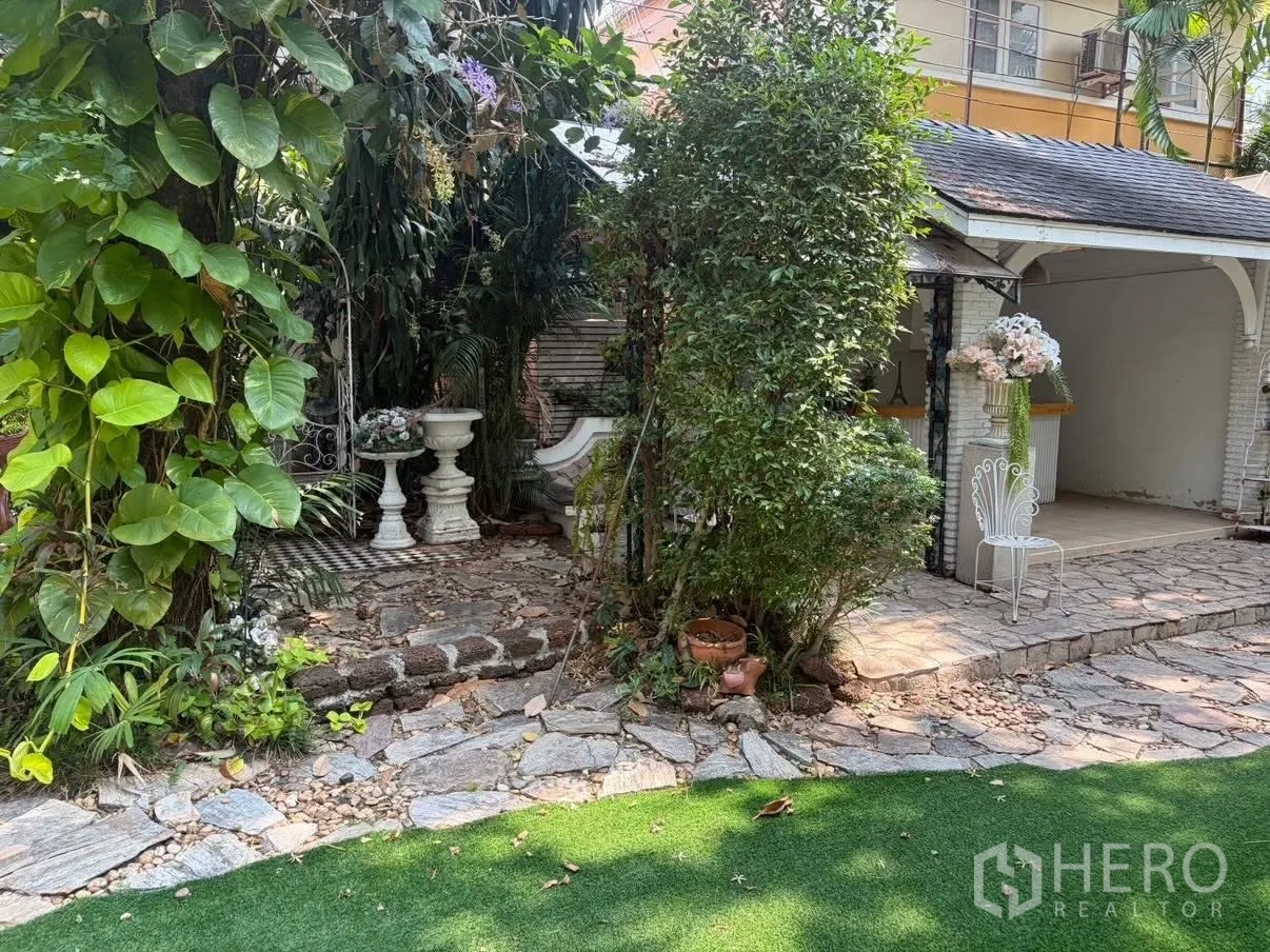 Detached House for rent in Phra Khanong, Bangkok - Leafy garden corner by patio steps with decorative planters.