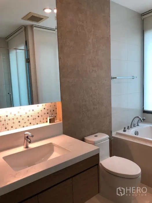 Condominium for rent or sale in Khlong Toei, Bangkok - Contemporary bathroom with vanity, toilet, mosaic backsplash, bathtub and glass shower.