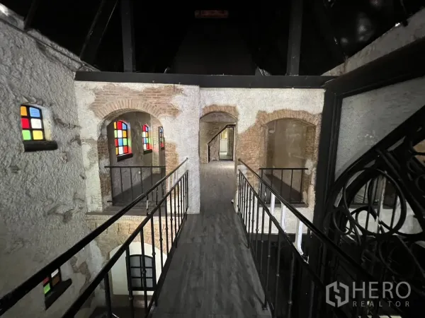 Retail Space for rent in Watthana, Bangkok - Mezzanine walkway with metal railings overlooking arched brick openings and stained-glass details.