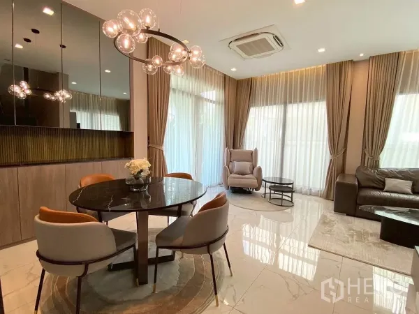 บ้าน ให้เช่าในBang Phli, Samut Prakan - มุมรับประทานอาหาร โต๊ะกลมสีดำ โคมไฟดีไซน์ และผนังกระจกเงาใกล้หน้าต่างบานใหญ่