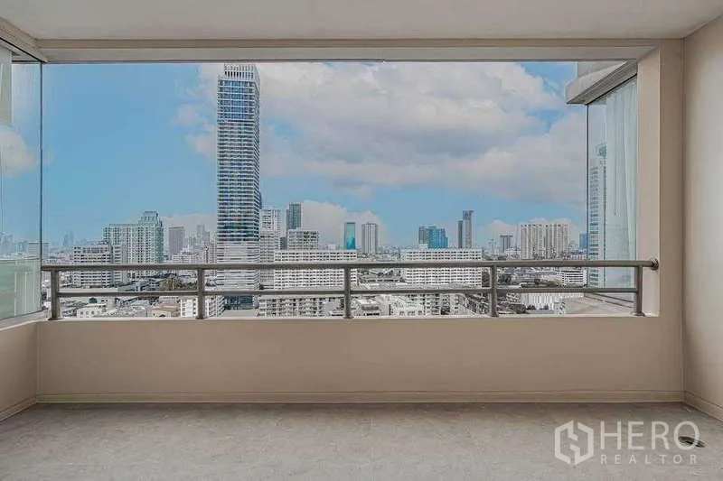 公寓 出租或出售在Watthana, Bangkok - 宽阔阳台，框景式曼谷天际线与玻璃防风板。